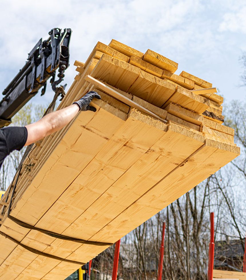 web-unloading-wooden-beams-from-truck-on-construction-2021-08-29-16-24-39-utc